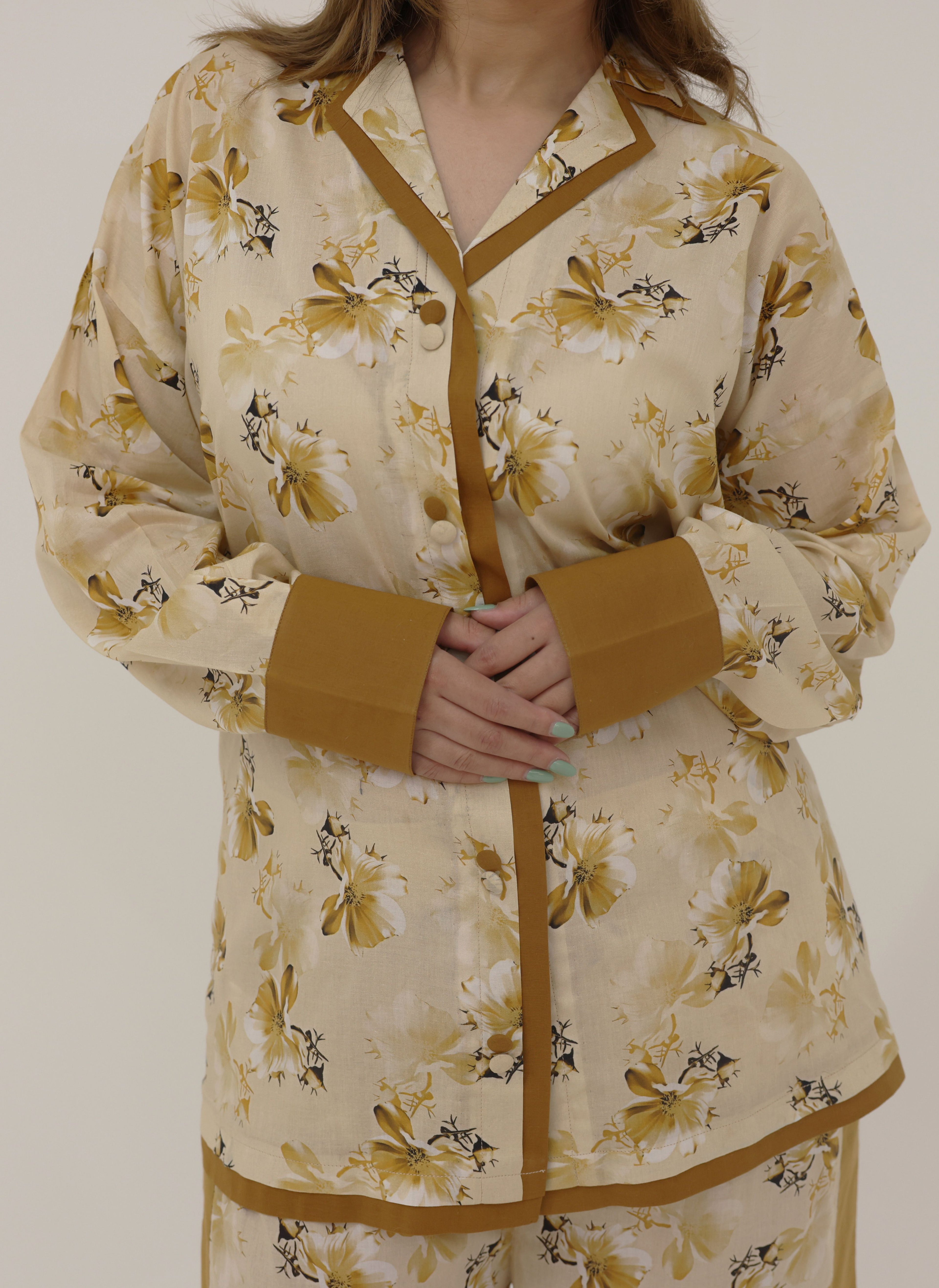 Beige floral dress with brown accents worn by a person on a plain background